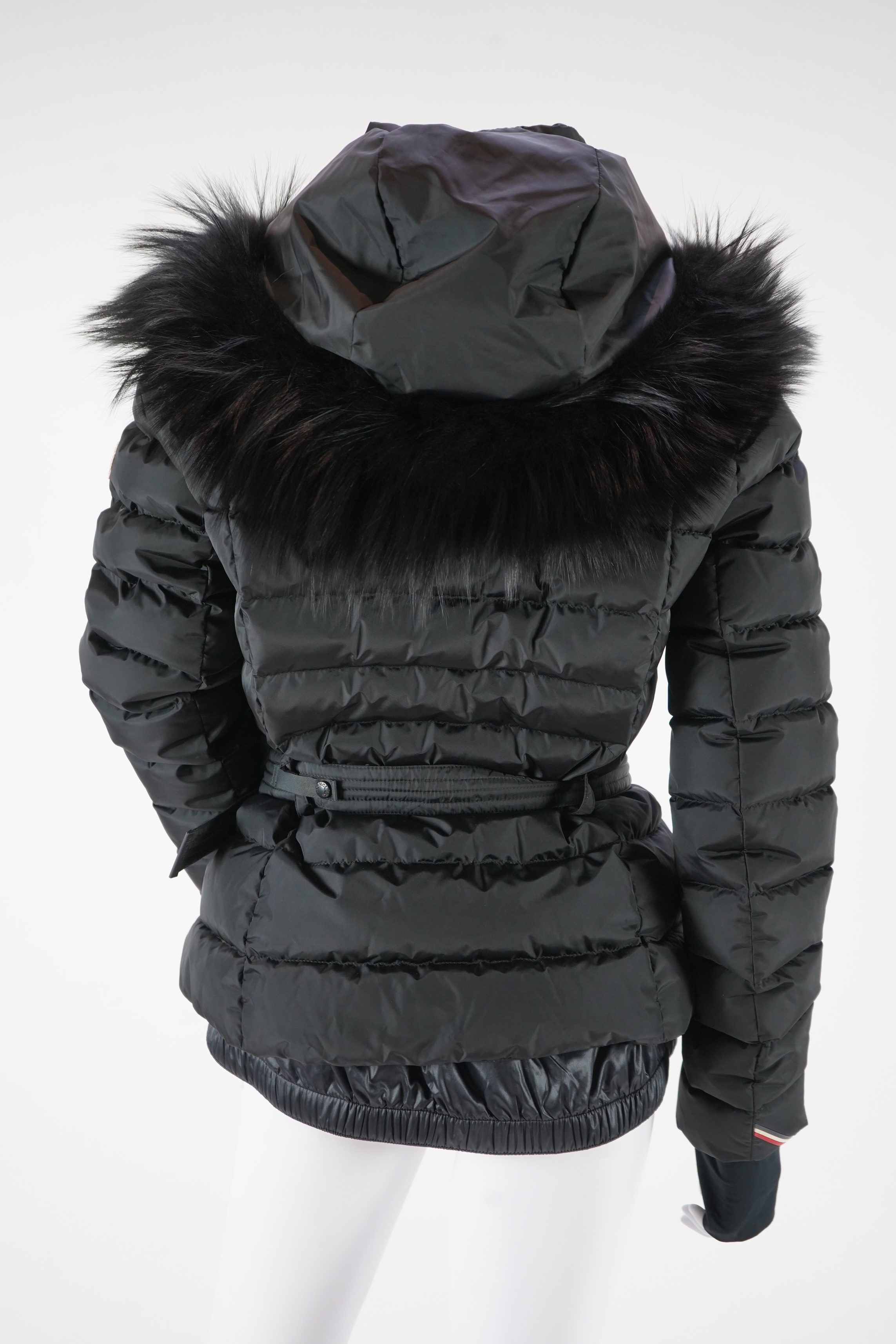 A lady's Moncler Grenoble down black ski jacket with fur trimmed hood and belted waist. UK size 10